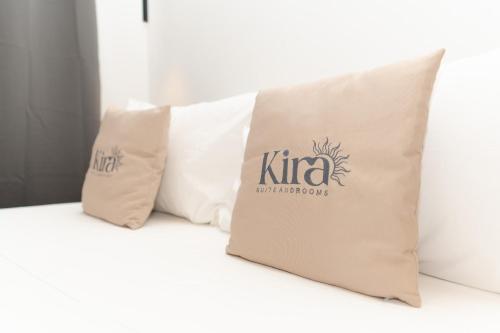 two pillows sitting on a couch with a kiruna logo on them at Kira suite and rooms in Pozzuoli