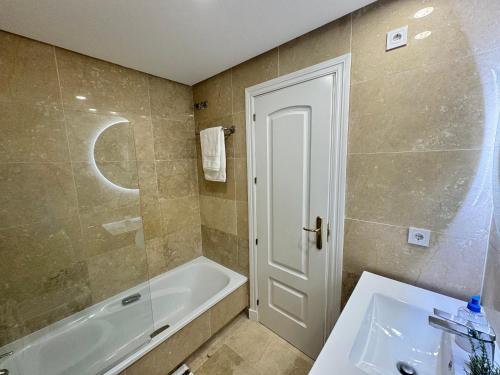 a bathroom with a bath tub and a sink at Puerto De La Duquesa in Manilva