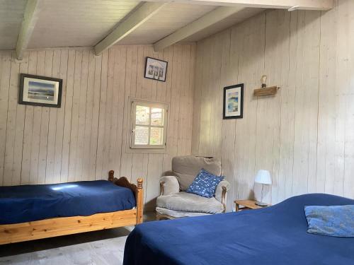 a bedroom with a bed and a chair and a window at Chambre à la venelle in Caen