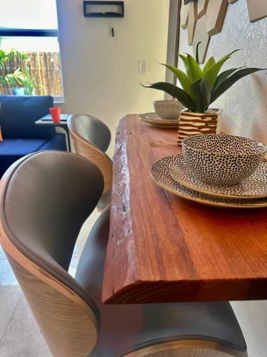 a wooden table with plates and a plant on it at Tropical Studio in Miami