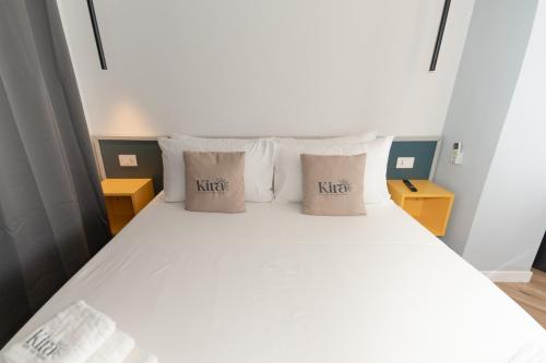 a bedroom with a bed with white sheets and pillows at Kira suite and rooms in Pozzuoli