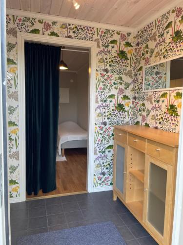 a room with a bedroom with floral wallpaper at Boende med vackra omgivningar in Borlänge