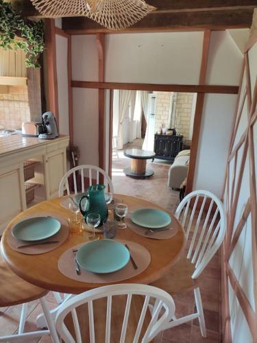 une table en bois avec quatre chaises et une salle à manger dans l'établissement Petit coin de campagne, à Marchéville
