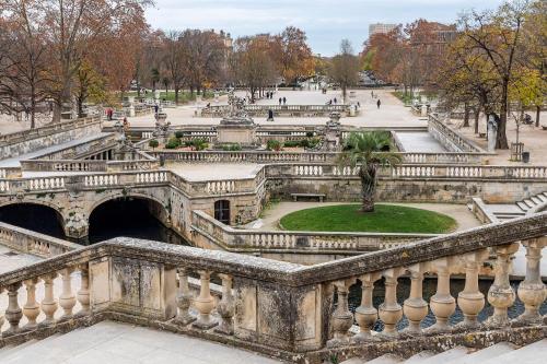 an old bridge in a park with a fountain at Maison "COSY" avec Parking Privé et Climatisation in Nîmes