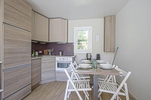 une cuisine avec une table et des chaises dans une pièce dans l'établissement Secret Garden joli cottage rénové proche mer, à Blonville-sur-Mer