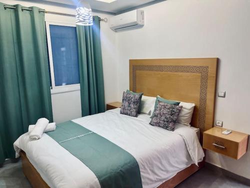 a bedroom with a large bed with green curtains at Cozy Family House in City-Center in Chefchaouene