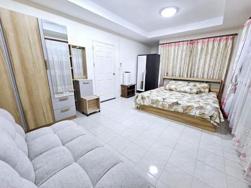 Un dormitorio con una cama y un sofá. en K T Greenvill, en Ban Khom