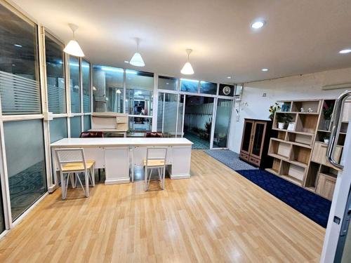 Habitación grande con cocina con barra y sillas. en K T Greenvill, en Ban Khom