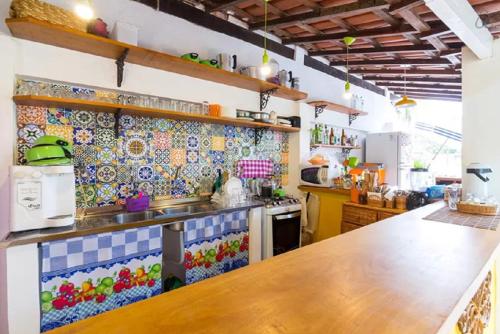 a kitchen with colorful tiles on the wall at Maracujá Hostel in Paraty