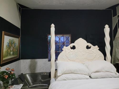 a bedroom with a white bed and a black wall at TSG sys Palace in Spring Garden