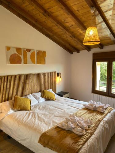 a bedroom with a large bed with towels on it at Apartamentos Rio Loba Ruiloba costa Cantabria in Ruiloba
