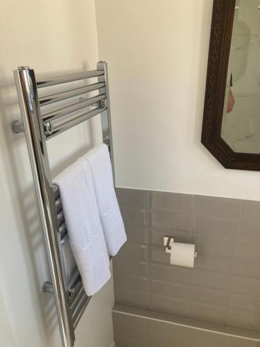 - Baño con toallero eléctrico y toallas blancas en 2 bed chalet romney sands, en Greatstone