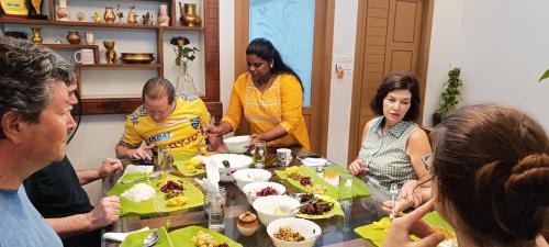 a group of people sitting around a table eating food at Oyster Marris Homestays in Trivandrum