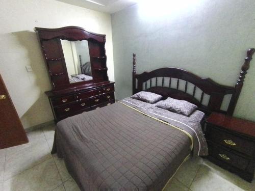 une chambre avec un lit, une commode et un miroir dans l'établissement El Refugio, à Oaxaca