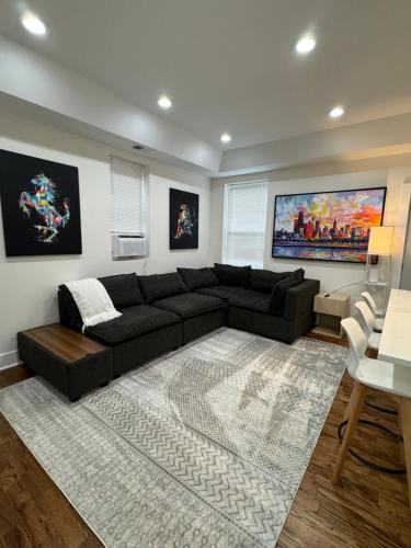 a living room with a black couch and a rug at Chic Euro City Getaway- Close to Downtown in Chicago