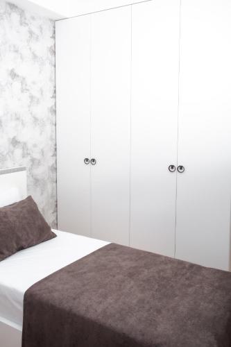 a bedroom with white cabinets and a white bed at Guesthouse - 3 room in Sumqayyt