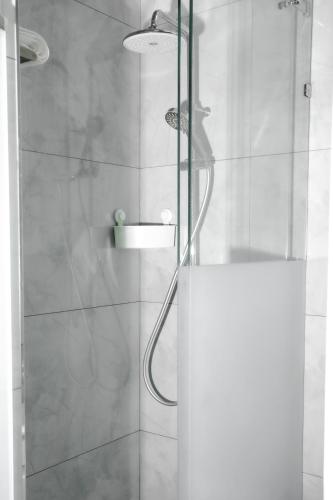 a shower stall with a glass door with a shower at Guesthouse - 3 room in Sumqayyt