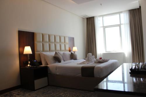 a bedroom with a large bed and a window at Dolphin Continental Hotel in Kuwait