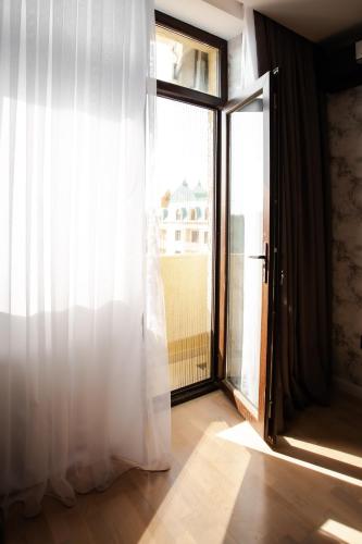 an open door with a white curtain and a window at Guesthouse - 3 room in Sumqayyt