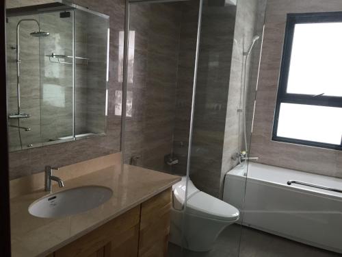 a bathroom with a sink and a toilet and a window at Hana Homestay in Hai Phong