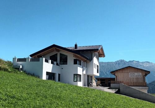 un bâtiment au sommet d'une colline avec de l'herbe verte dans l'établissement Haus Eisenhut INKLUSIVE SuperSommerCard, à Fiss
