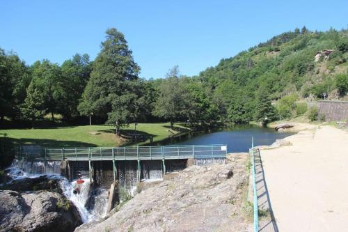 a bridge over a waterfall next to a beach at Maisonnette à la campagne in Colombier-le-Jeune