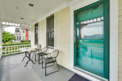 a front porch with chairs and a table and a door at Charming Victorian Retreat with Hudson River Views in Newburgh