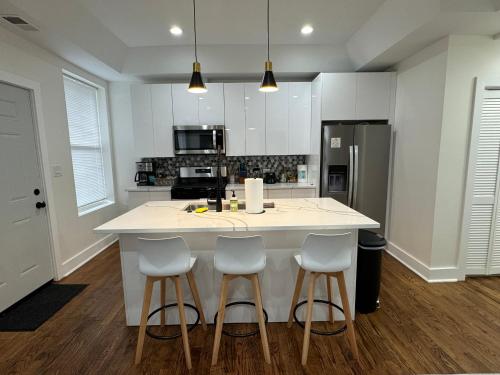 a kitchen with a large island with four bar stools at Chic Euro City Getaway- Close to Downtown in Chicago