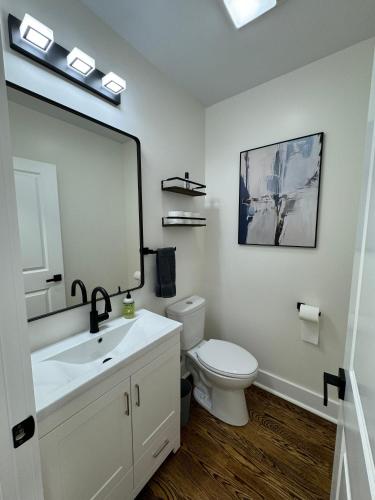 a bathroom with a sink and a toilet and a mirror at Chic Euro City Getaway- Close to Downtown in Chicago