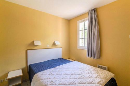 une petite chambre avec un lit et une fenêtre dans l'établissement Résidence le Hameau de Cap Esterel - maeva Home - Appartement 2 pièces 7 personnes - Confort MAE-2401, à Saint-Raphaël