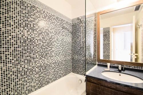 une salle de bain avec un lavabo, une baignoire et un miroir dans l'établissement Résidence le Hameau de Cap Esterel - maeva Home - Appartement 2 pièces 7 personnes - Confort MAE-2401, à Saint-Raphaël