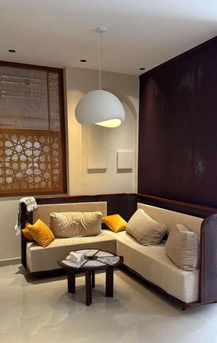 a living room with a couch and a table at Alhamra Horizons in Al Ḩamrāʼ