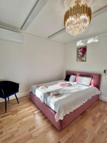 a bedroom with a large bed and a chandelier at Kalna iela 21 apartment in Sigulda