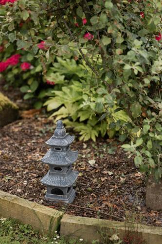 a gray pagoda sitting in the middle of a garden at LakEscape - Waterfront Self- Catering Cabins in Enniskillen