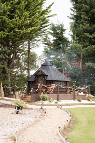 a small building in a garden with a fence at LakEscape - Waterfront Self- Catering Cabins in Enniskillen