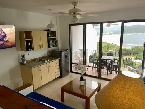- un salon avec une cuisine offrant une vue sur l'océan dans l'établissement Palma Real vista al mar, à Manzanillo