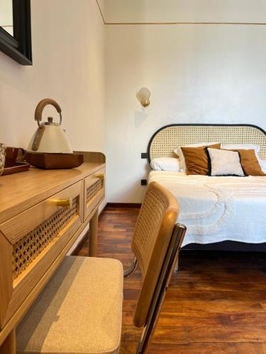 a bedroom with a bed and a table and a chair at Savoy Hotel in Le Bourget-du-Lac