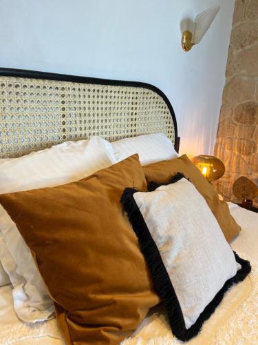 a bed with brown and white pillows on it at Savoy Hotel in Le Bourget-du-Lac