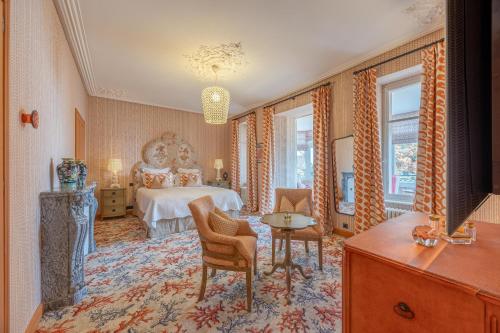 a bedroom with a bed and a table and chairs at Villa Haute Guais, maison et table d'hôtes vue mer in Dinard