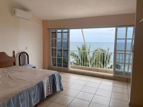 a bedroom with a bed and a view of the ocean at La Casa del Risco in Lázaro Cárdenas