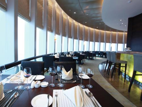 a dining room with tables and chairs with wine glasses at HJ International Hotel in Dongguan