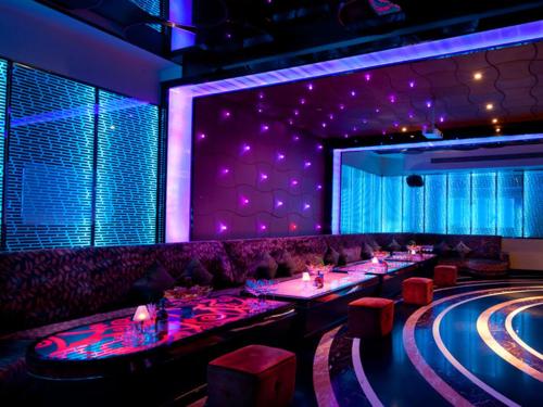 a bar with purple lighting and a bowling alley at HJ International Hotel in Dongguan