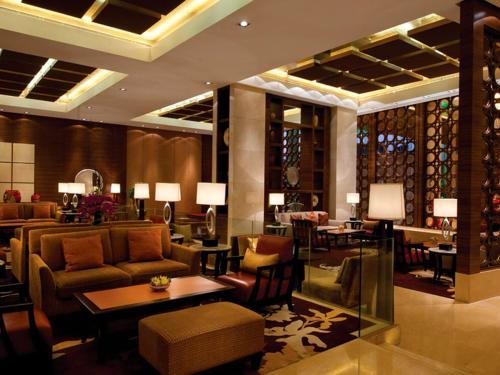 a lobby of a hotel with couches and tables at HJ International Hotel in Dongguan