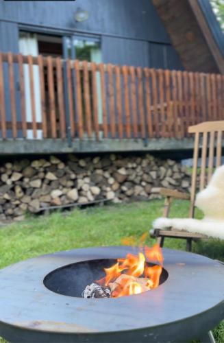 a fire pit in a yard next to a chair at Le ChAlet N5 in Cierp