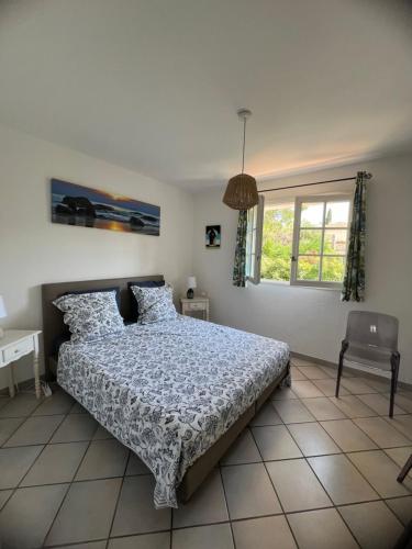 une chambre avec un lit, une chaise et une fenêtre dans l'établissement Villa Alessia, villa provençale à Antibes, à Antibes