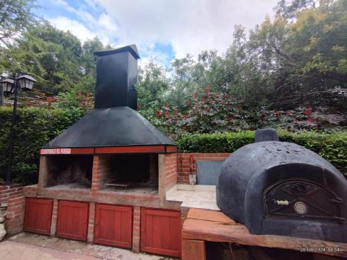 an outdoor pizza oven sitting on top of a patio at A Mi Manera Apart in Merlo
