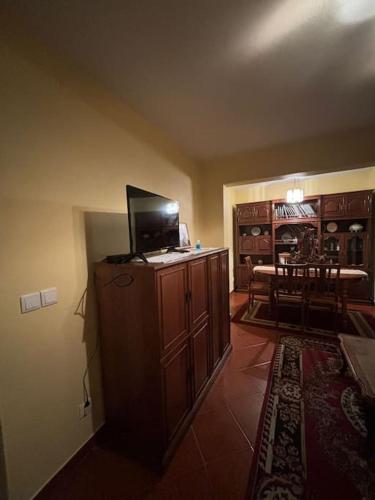 a living room with a tv on top of a cabinet at Casa das Oliveiras in Celorico de Basto