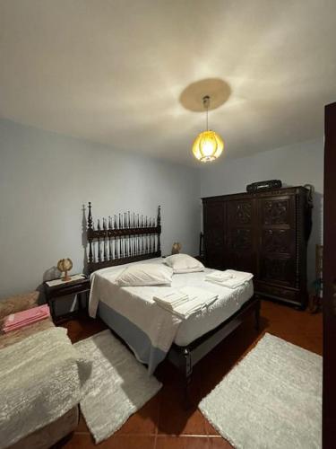 a bedroom with a bed and a dresser and rugs at Casa das Oliveiras in Celorico de Basto