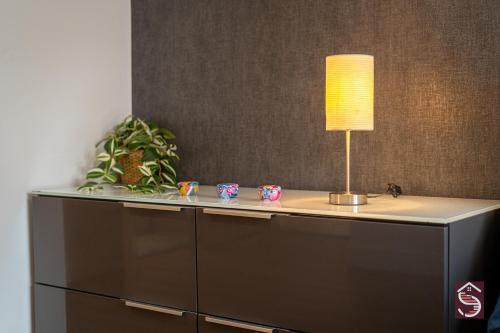a desk with a lamp on top of it at The Canning Comfort in London