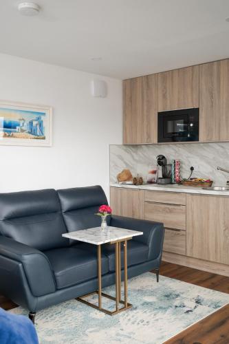 a living room with a black couch and a table at LakEscape - Waterfront Self- Catering Cabins in Enniskillen